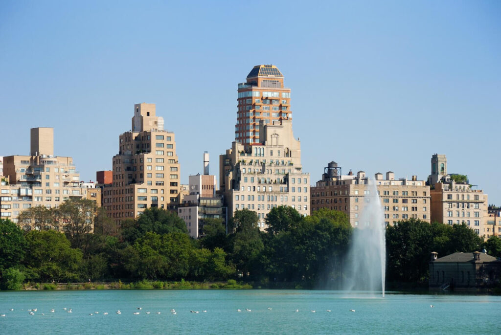 Central Park Reservoir with city skyline and water fountain.