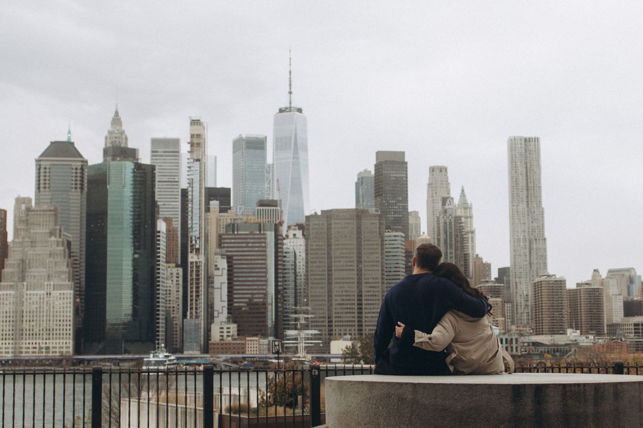 Couple embracing while looking at the New York City skyline.