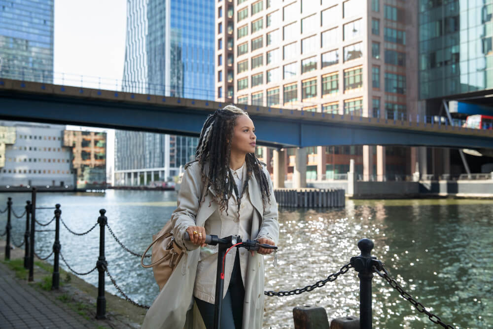 woman-at-a-city-looking-out-at-the-river-with-buildings-bridge-in-the-background